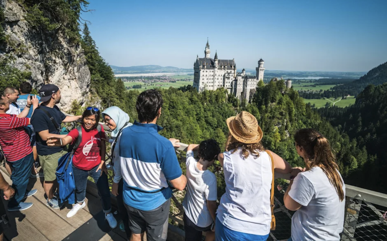 Turister beundrar Neuschwanstein från utsiktsplatsen – Europas mest kända slott.