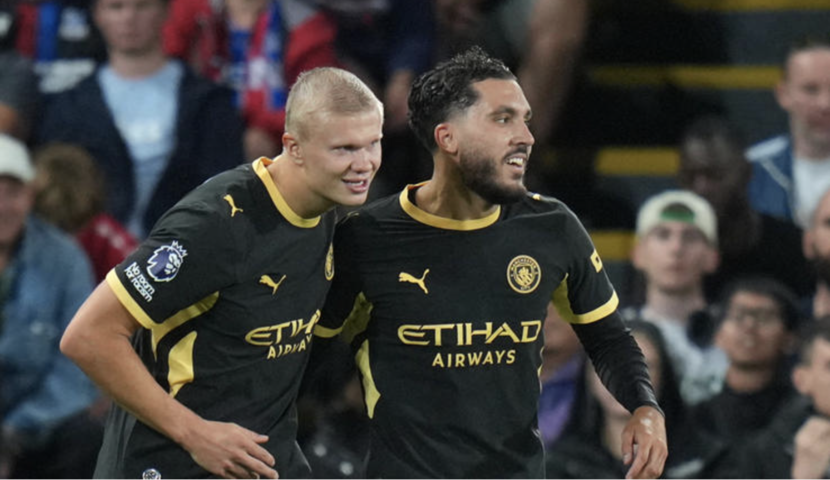 Två Manchester City-spelare i svarta bortatröjor jublar tillsammans på planen