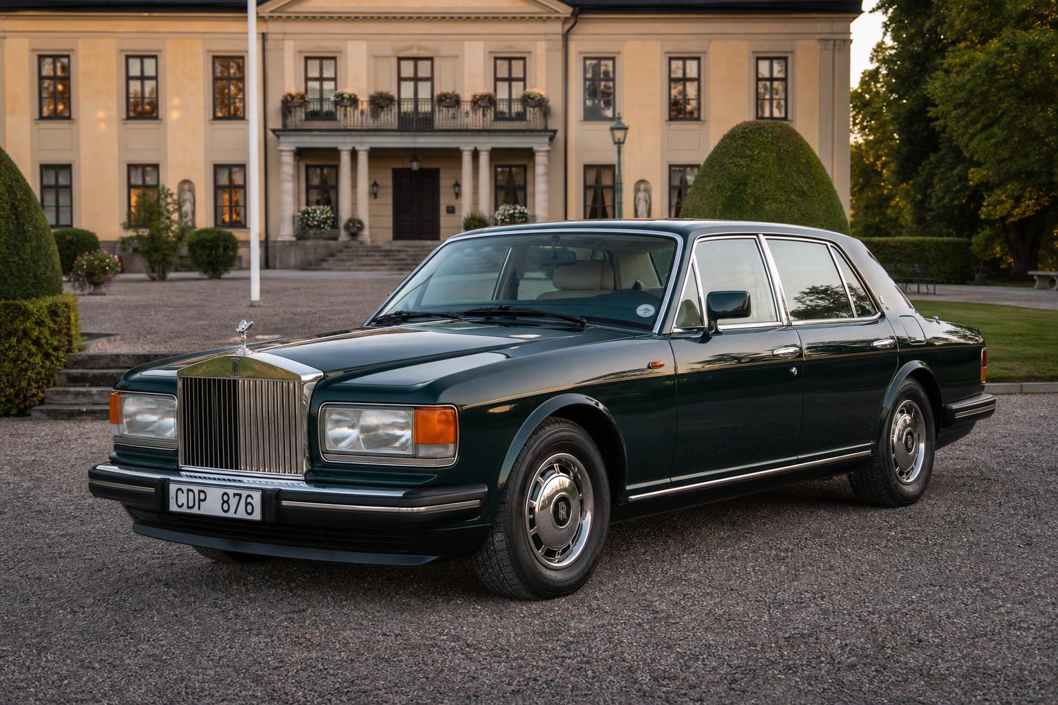 Mörkgrön Rolls-Royce Silver Spirit med vit svensk registreringsskylt CDP 876 parkerad framför en herrgård i kvällsljus