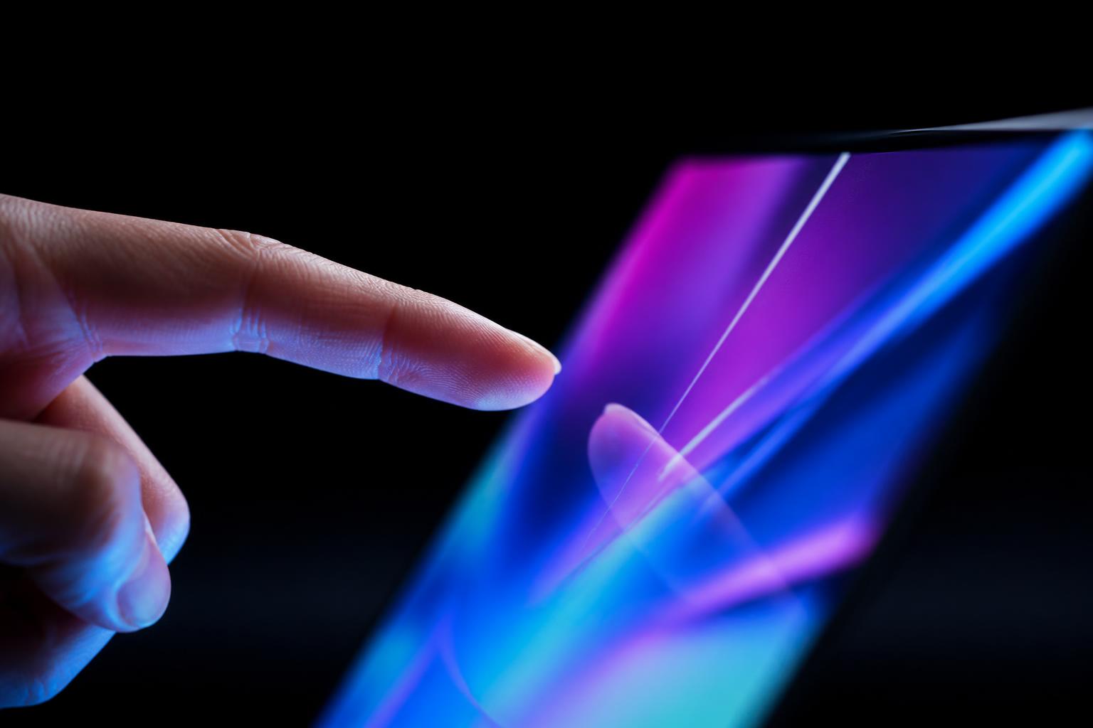 Finger som pekar mot en lysande OLED-skärm