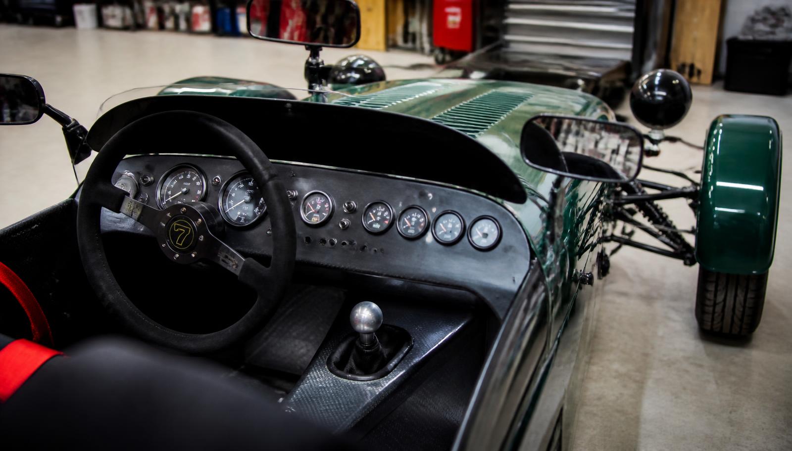Cockpit i en liten lättviktssportbil med ratt och analoga instrument