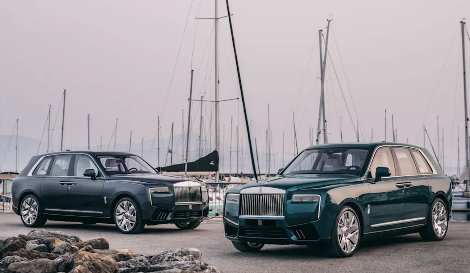 Två Rolls-Royce Cullinan i hamnmiljö, en mörkblå och en turkosgrön med beige överdel