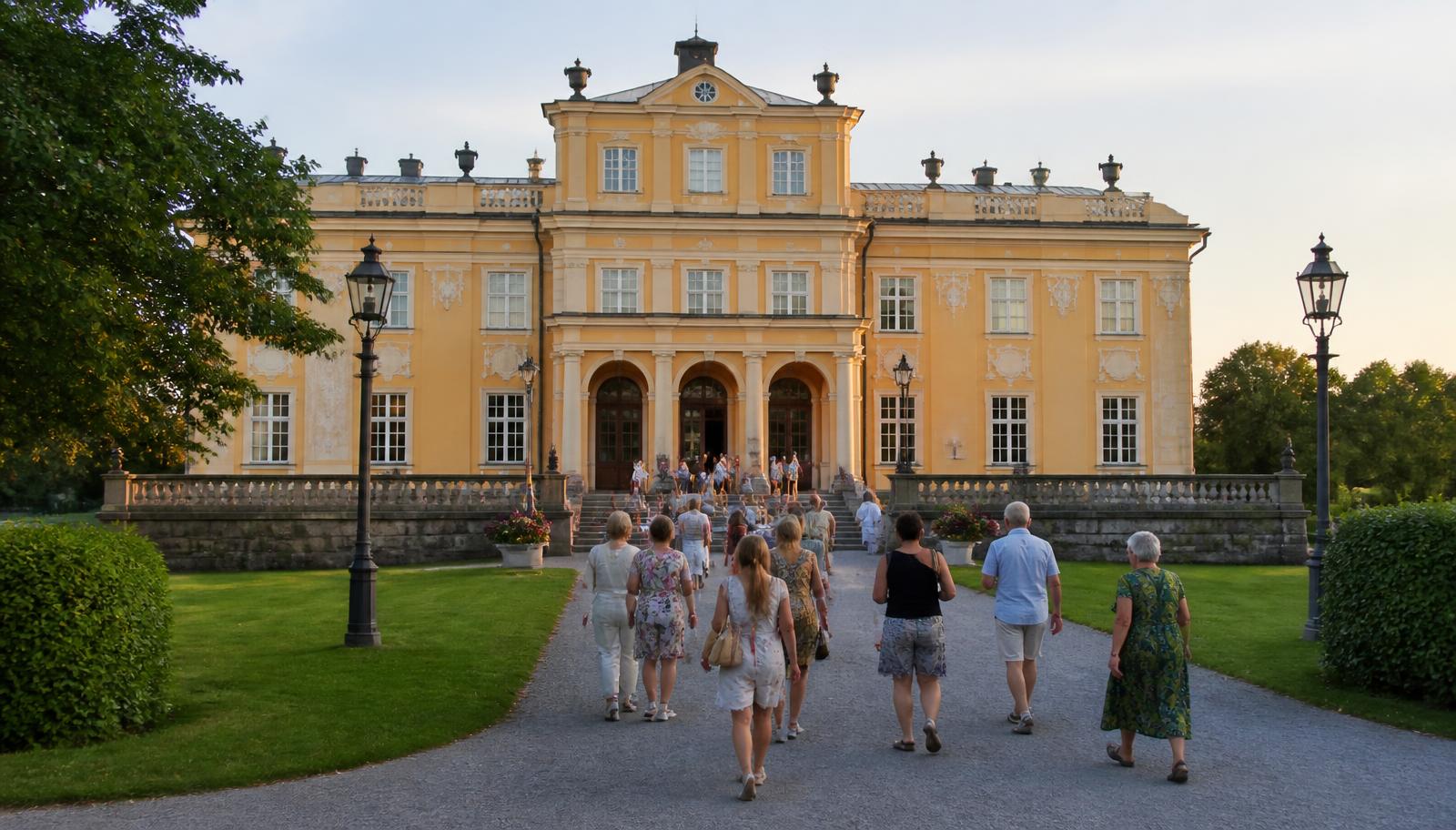 Publik på väg in till slottsteatern en sommarkväll