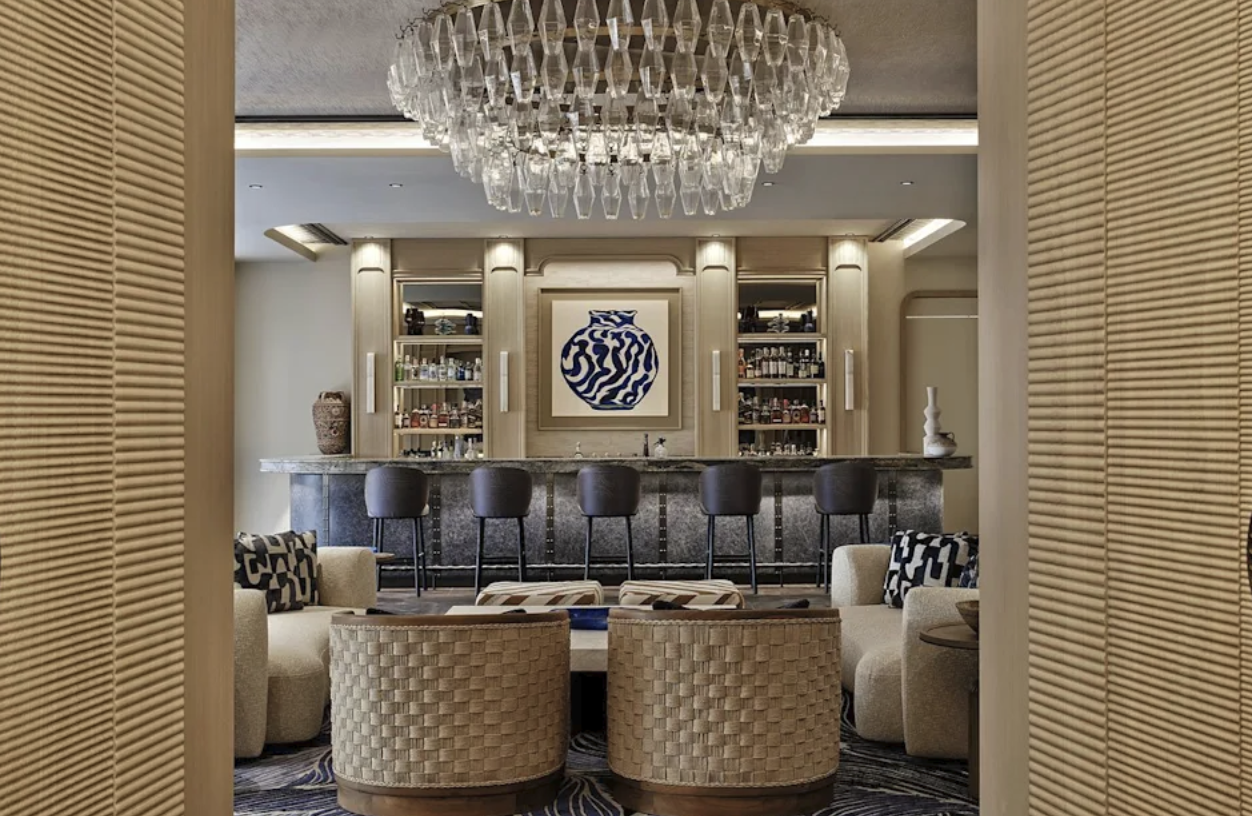 Elegant hotellbar med stor kristallkrona och vävda fåtöljer