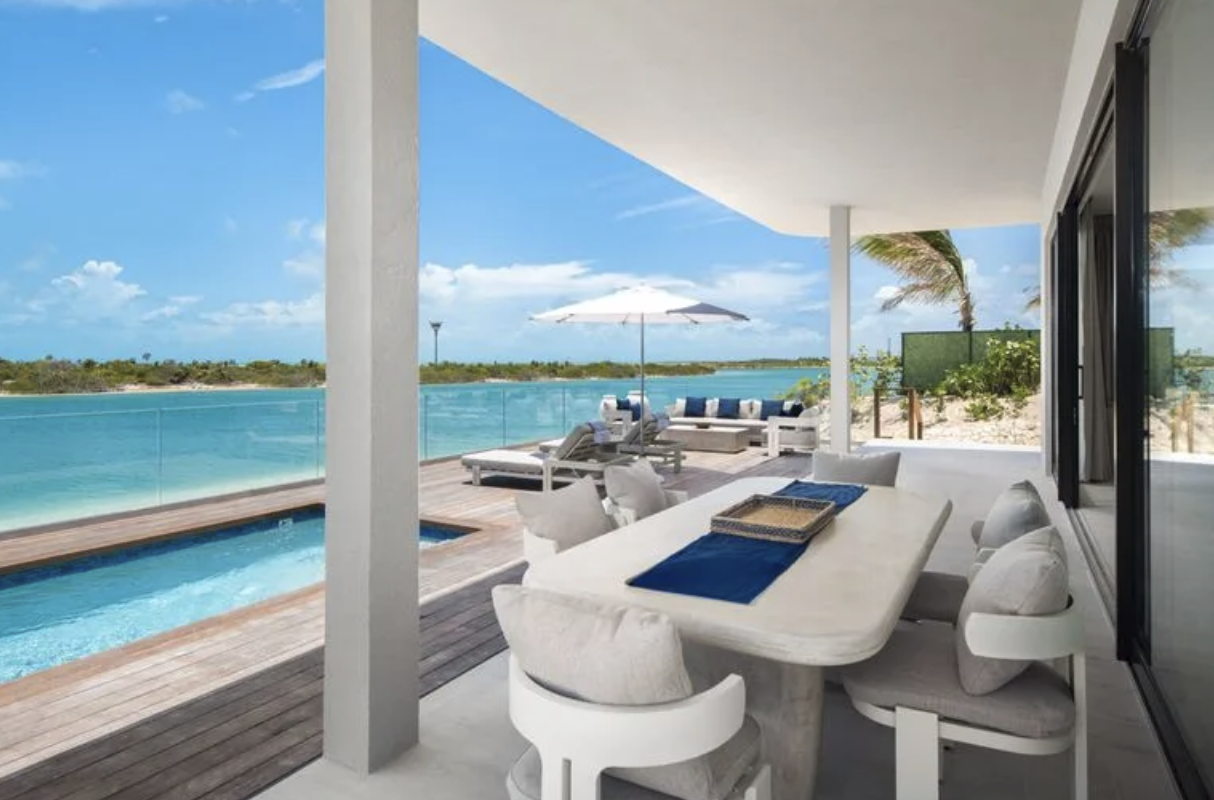 Terrass med privat pool vid turkost vatten på Ambergris Cay