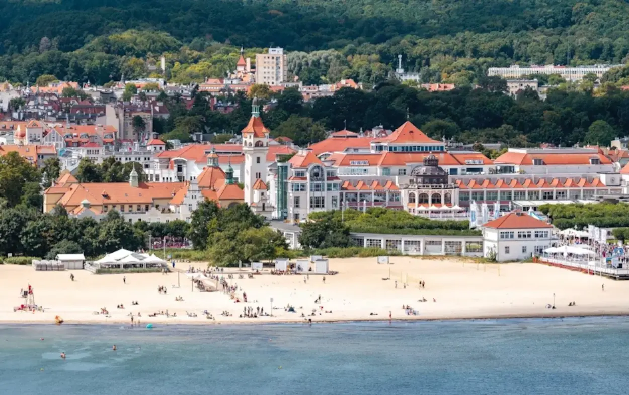 Badorten Sopot i Polen med bred sandstrand, badgäster och gamla spahus