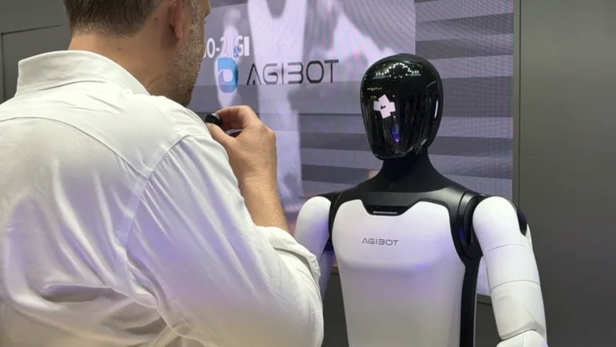 Mässbesökare samtalar med en Agibot-robot