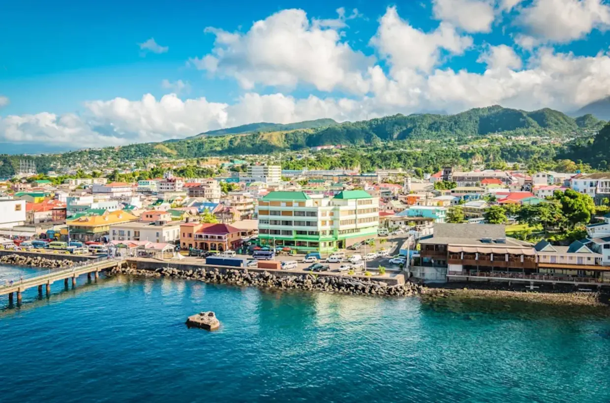 Färgglad hamnstad på Dominica med gröna berg i bakgrunden
